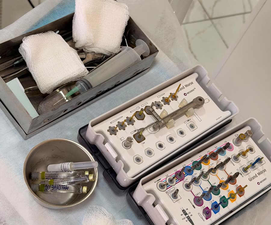 Kits de instrumentos para implante organizados sobre a mesa, com gazes e cuba de inox